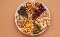 Top view of nuts, beans, and seeds on a plate, ideal for healthy dining themes.