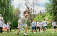 Group of children enjoying outdoor playtime in a green park during summer.